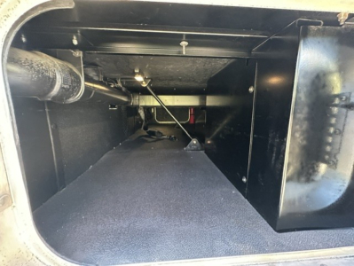 Kenworth T680 truck storage area with open rear underseat space showing clean black interior and support components.