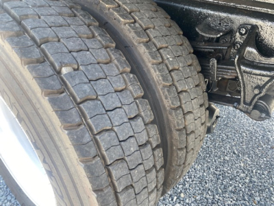 Truck dual rear wheels showing heavy tread tires and rear suspension components in the wheel well of a 2007 International 7400 dump truck.