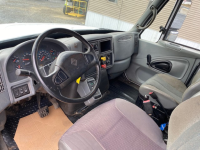 Dashboard and driver-side interior of a 2007 International 7400 dump truck showing steering wheel, instrument cluster, and front seating.