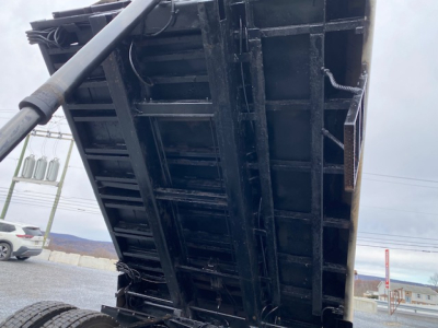 Dump bed of a 2007 International 7400 truck in vertical orientation showing black steel bed with hydraulic cylinder and support beams.