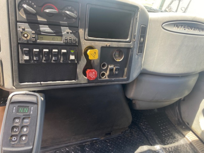 Interior dash of a 2007 International 7400 truck showing gear shifter, control switches, and knobs with steering wheel area and International badge.