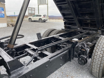 Truck chassis and dump body in open view showing frame and suspension components.