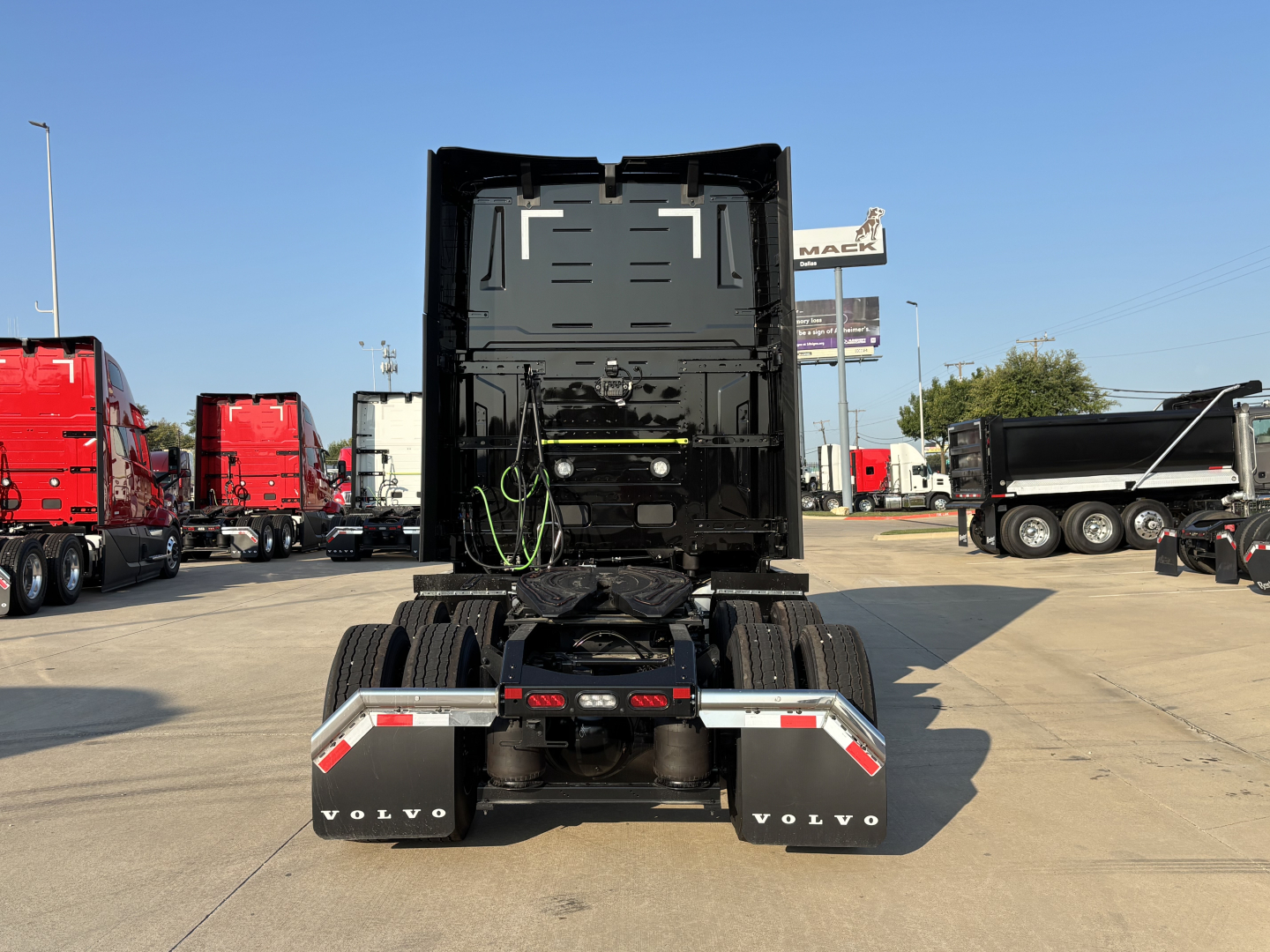Truck rear view showing fifth wheel and chassis of a new Volvo VNL64T860 in a dealership lot.