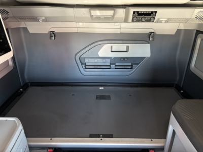 Volvo VNL64T860 cargo area behind sleeper with storage panels and floor hatch showing interior components.