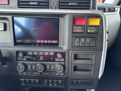 Volvo VNL64T860 dash area showing touchscreen display and climate controls, with gear and control panels in center console.
