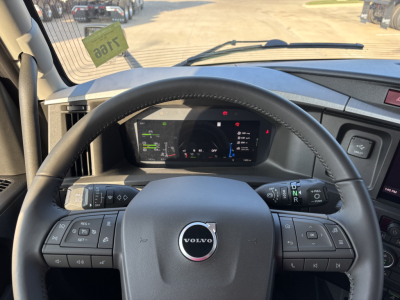 Volvo VNL64T860 interior steering wheel and dashboard showing digital instrument cluster and controls on steering wheel.