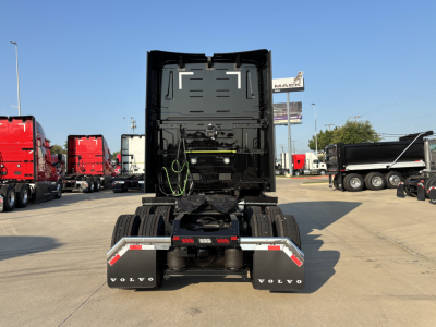 Truck rear view showing fifth wheel and chassis of a new Volvo VNL64T860 in a dealership lot.