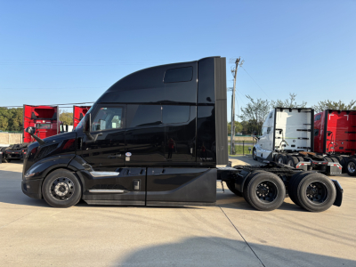 Side view of a black Volvo VNL64T860 semi-truck tractor with sleeper cab. No visible text on tractor.