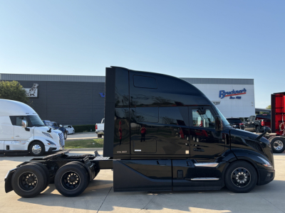 Volvo VNL64T860 tractor cab side view showing sleek black exterior and sleeper cab with dual rear axles, factory decal faintly visible.