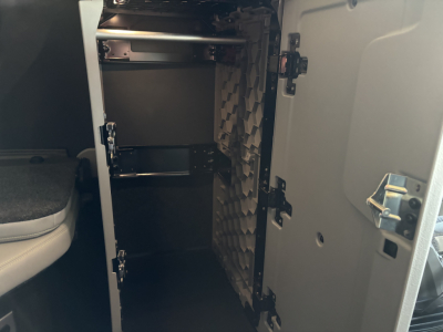 Volvo VNL64T860 sleeper cab storage compartments open showing shelves and partitioned interior with foam padding on wall.