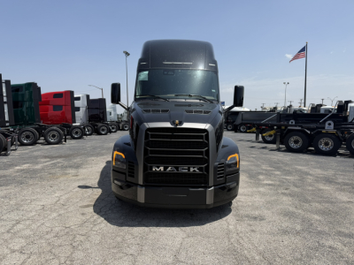 Front view of a new Mack PR64T76H sleeper cab truck in a dealership lot with other trucks in background.