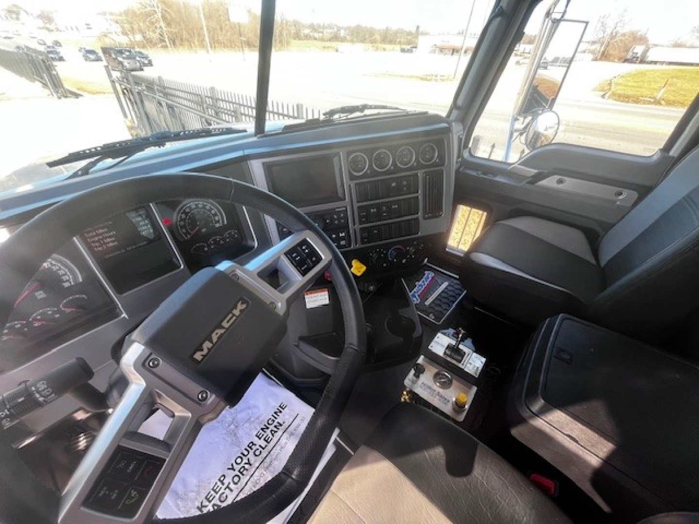 Cab interior of a 2026 Mack PI64 showing steering wheel with MACK logo, dashboard gauges, center console, and driver seat.