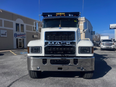 Front view of a white 2026 Mack PI64 dump truck showing large grille with MACK lettering, bumper, and headlights; includes stock number 69214 and dealership backdrop.