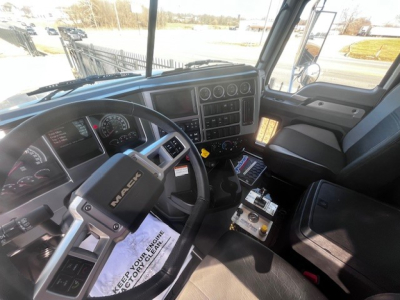 Cab interior of a 2026 Mack PI64 showing steering wheel with MACK logo, dashboard gauges, center console, and driver seat.