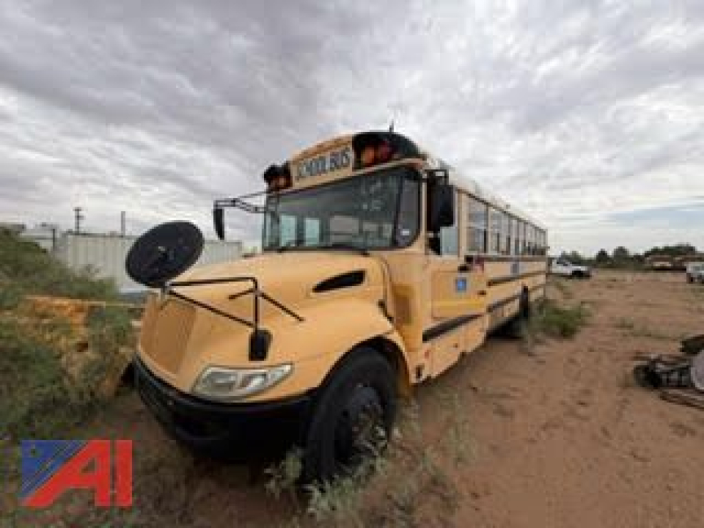 School bus CE Series 2008 IC Corporation bus in yellow, front-left view, two-vision mirrors, roof emergency lights, bus sign on windshield, dirt lot background.