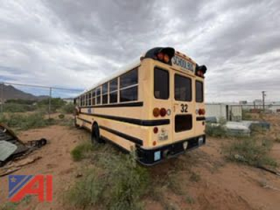 Bus CE Series school bus rear view showing number 32 and taillights in a desert lot.