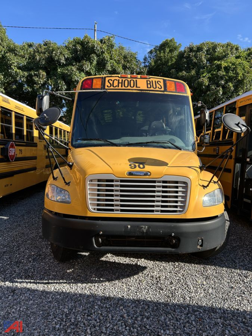 School bus front view showing yellow Freightliner bus with large grille and 'SCHOOL BUS' sign above windshield.