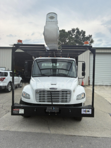 Front view of a 2018 Freightliner M2 106 bucket truck with a raised aerial lift, black front bumper and cage, stock number 534-213.