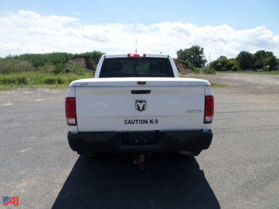 Ram 1500 pickup truck rear view showing CAUTION K-9 badge and RAM emblem