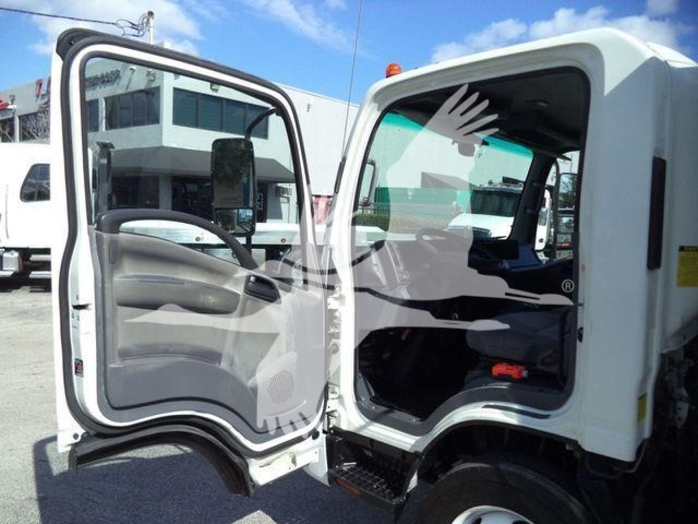 Isuzu NPR-HD cab interior and door area showing open driver and passenger doors with cab step and dashboard details.