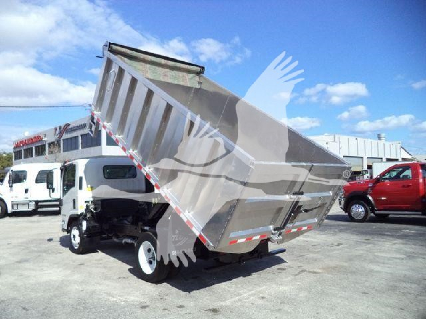 Isuzu NPR-HD dump truck with bed raised, front view showcasing hydraulic lift and dump body