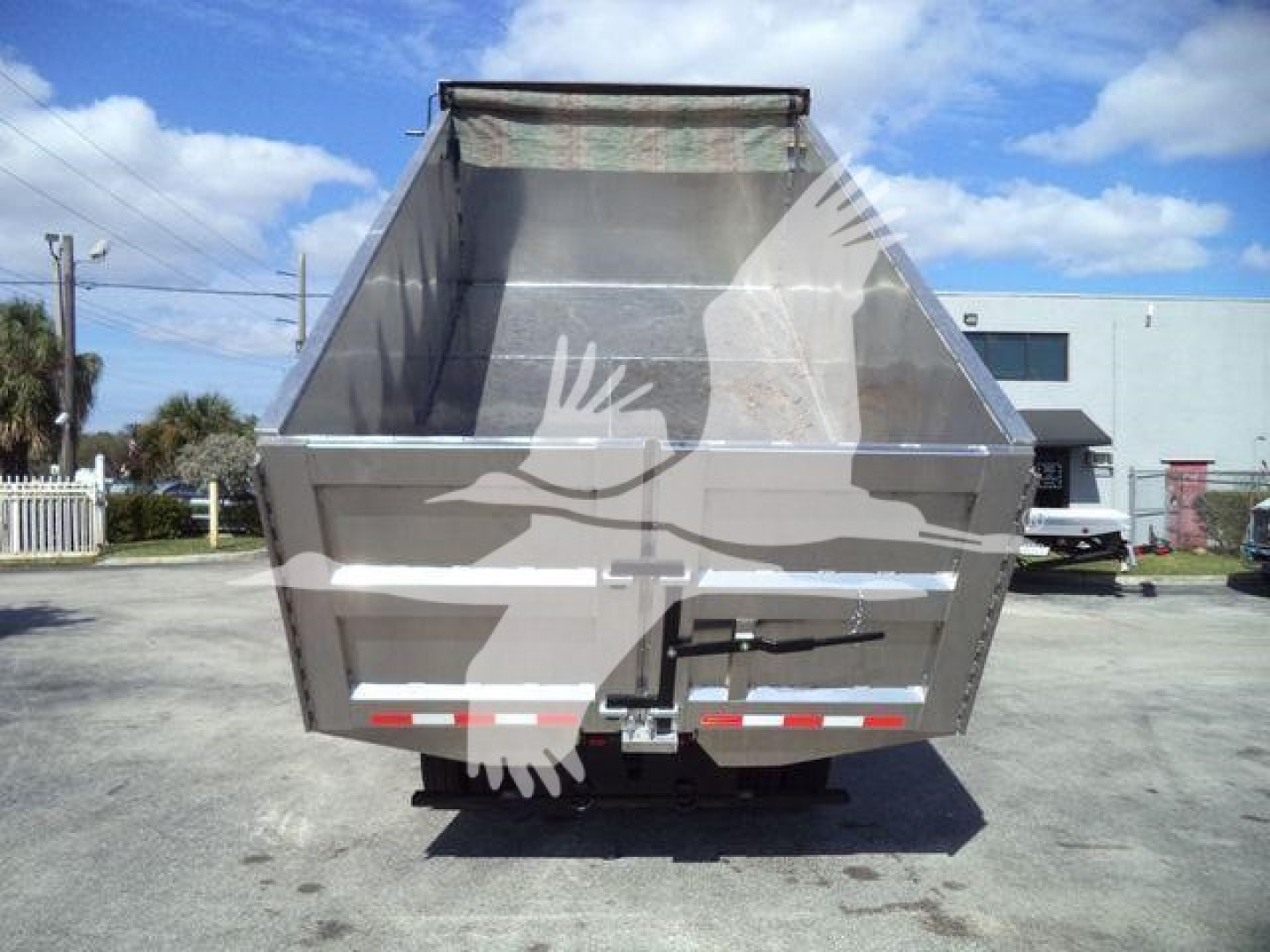 Isuzu NPR HD dump bed viewed from rear showing open cargo area and tailgate.