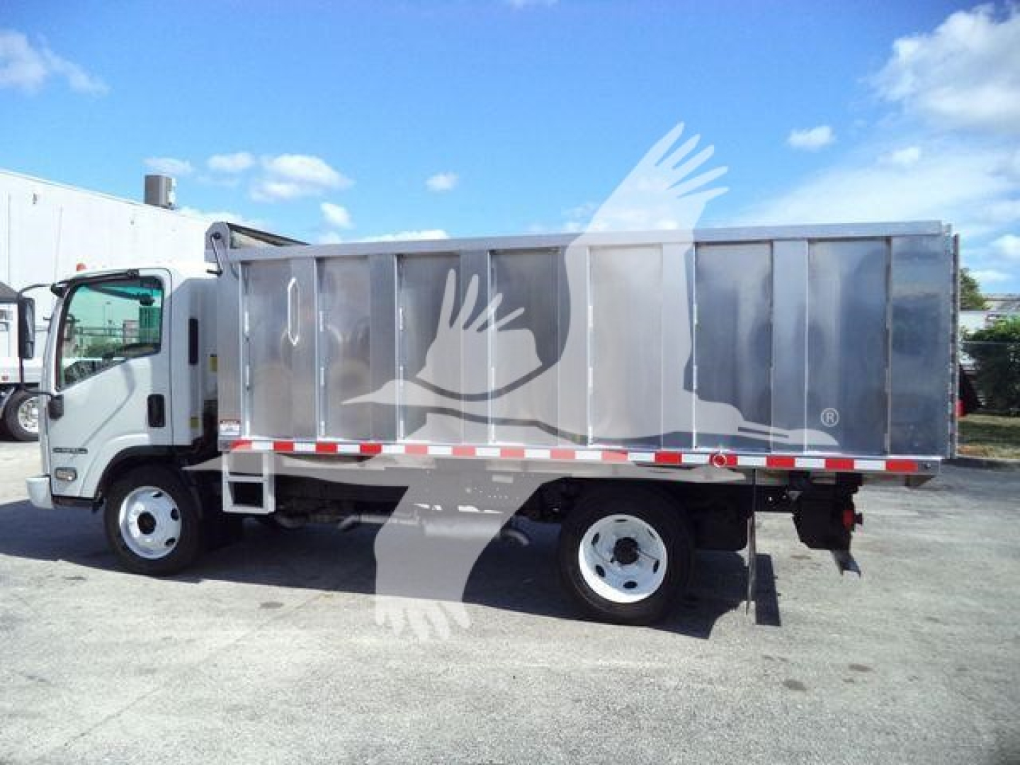 Isuzu NPR-HD dump truck in profile showing side cargo bed and cab, with stock number tag visible in listing.