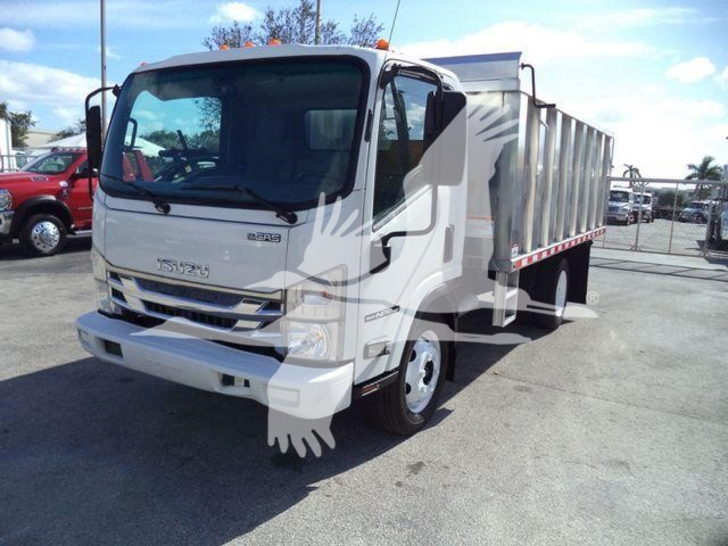 Isuzu NPR-HD dump truck in a dealership lot, white cab with gray dump bed, stock number T04505FM, front view with windshield, headlights, and mirrors visible.