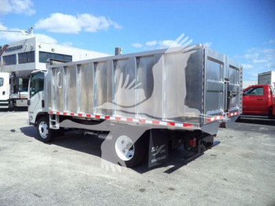 Isuzu NPR HD dump truck body side view showing metal dump bed and rear doors with safety reflectors.