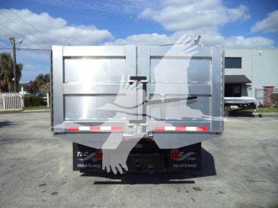 Isuzu NPR HD dump truck bed rear view showing tailgate with latch, reflective red/white tape, and Isuzu branding on the bumper area