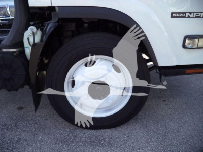 Isuzu NPR HD truck front wheel and fender showing wheel, tire, and partial cab with Isuzu NPR badge.