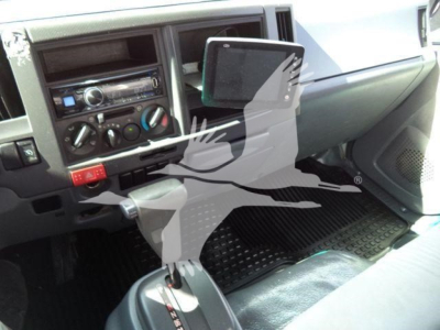 Isuzu NPR HD interior dashboard and center stack showing radio, climate controls, and fold-out clipboard/tablet mount.