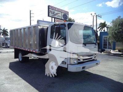 Isuzu NPR-HD truck in a lot with a metal dump bed, front view, cab and cargo area visible; no legible labels or stickers readable on the truck from this distance.