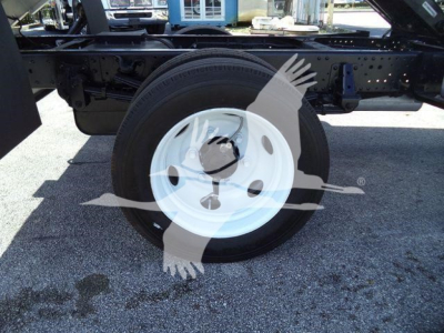 Wheel and chassis side view of a 2017 Isuzu NPR HD truck showing a white steel wheel with black tire and surrounding frame components.