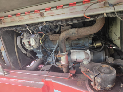 Engine compartment of a 2012 piggyback lift equipment showing diesel engine components and tubing.