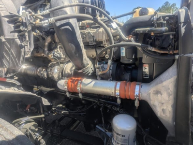 Freightliner Cascadia 126 engine bay showing hoses, coolant reservoir, and air filter housing.