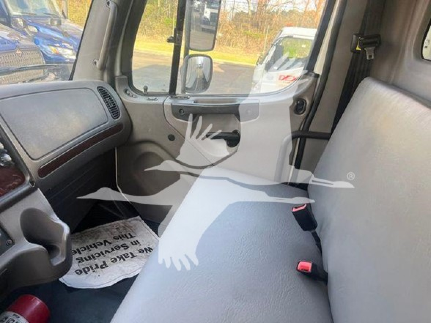 Cab interior of 2019 Freightliner M2 106 truck showing front dashboard and passenger seat area.