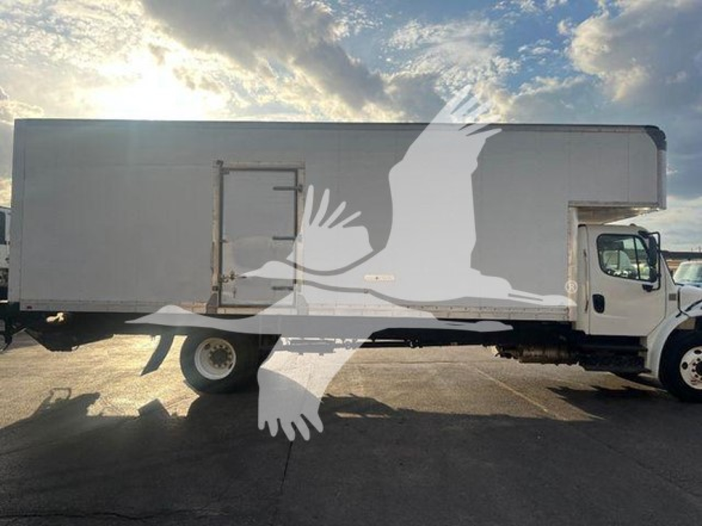 Truck side view showing a 2019 Freightliner M2 106 moving van, long box body, cab at right, stock TE7384.