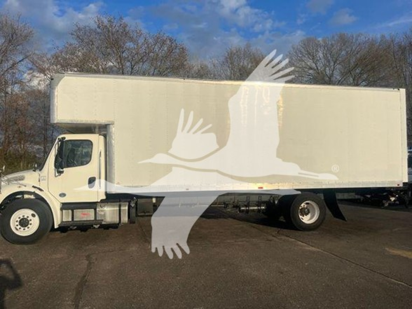 Truck side view showing a white moving van box on a Freightliner M2 106 chassis with plain white exterior.