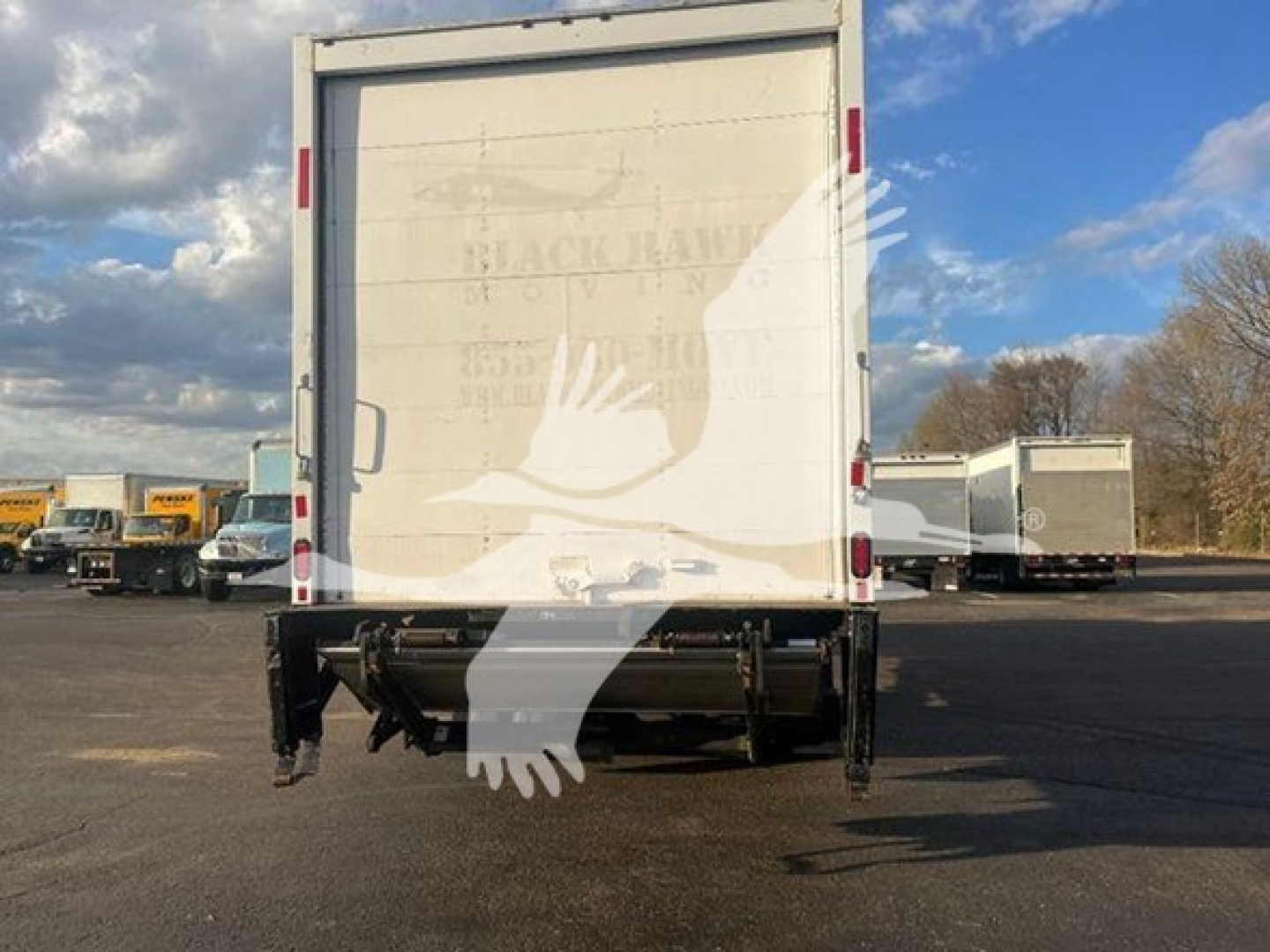 Rear view of 2019 Freightliner M2 106 moving van with lift gate and undercarriage components visible.