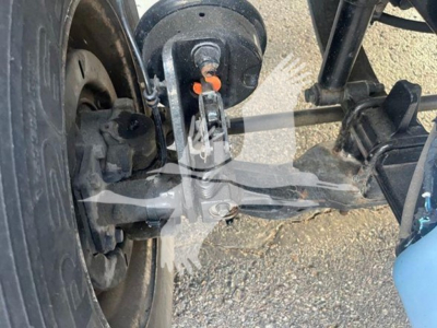 Truck front suspension and steering linkage of a 2019 Freightliner M2 106 showing steering arm, tie rod, and wheel hub with brake components.