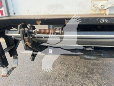 Truck rear undercarriage showing hydraulic door closer and torsion rod on Freightliner M2 106 tail area