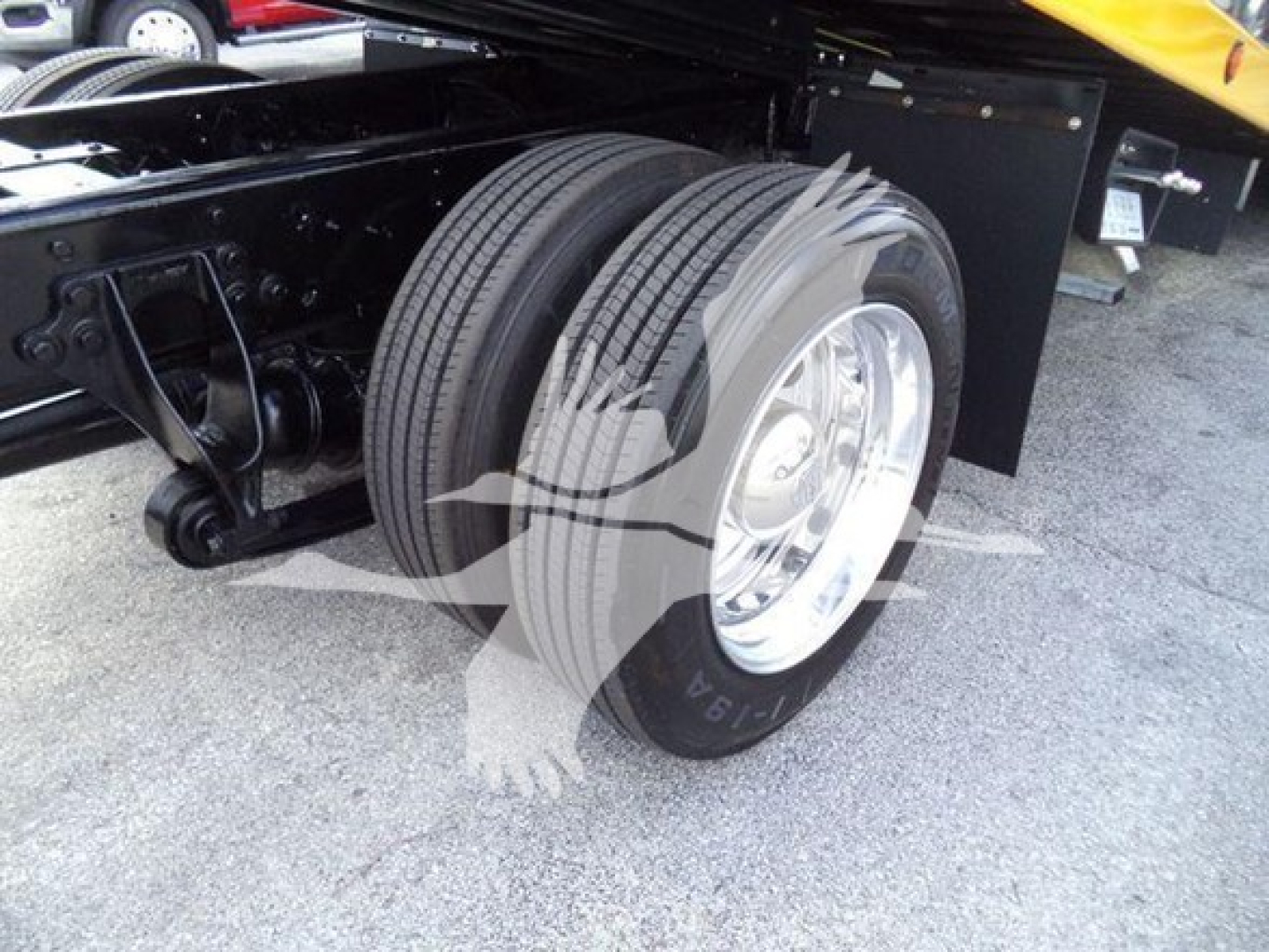 Truck rear wheel assembly of a 2019 International Durastar 4300 rollback showing dual rear tires and suspension components.