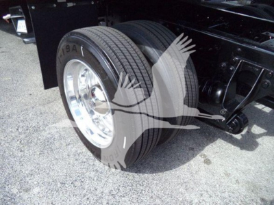 Truck rear dual tires and chassis view showing heavy-duty suspension and steel frame.
