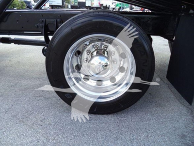 Wheel and tire of a 2019 International Durastar 4300 rollback truck showing chrome steel wheel and black tire, undercarriage components visible.