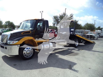Truck: 2019 International Durastar 4300 rollback w/ black and yellow cab, flatbed tow trailer, side mirror, and chrome front bumper. VIN and stock number not visible on this angle.