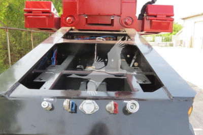 Truck trailer deck with control valves and levers showing hydraulic lines and fittings in a lowboy trailer.