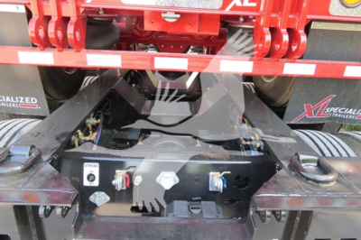 Trailer hitch area of a XL Specialized 110Hdg-15 lowboy trailer showing hydraulic controls and mounting hardware with safety latches.