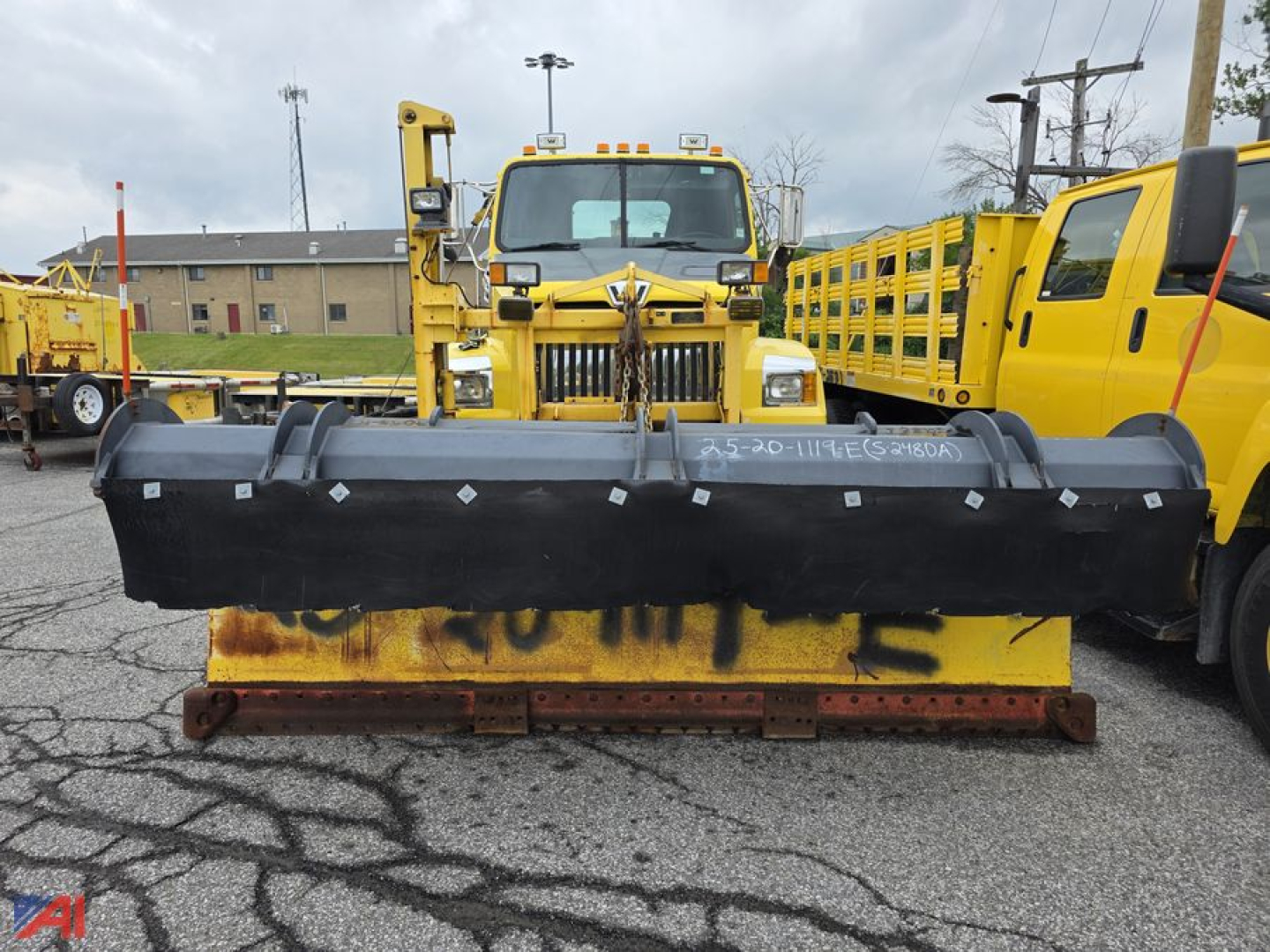 Western Star 4700 SF cab & chassis with front plow and Viking Wing attachment in an equipment yard.