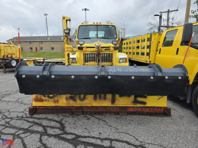 Western Star 4700 SF cab & chassis with front plow and Viking Wing attachment in an equipment yard.